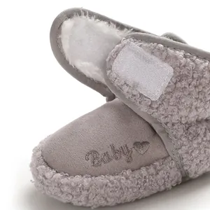 Close-up detail of grey baby snow boots showing soft sherpa lining and heart embroidery