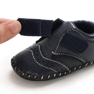 Close-up of navy blue leather baby shoe showing adjustable hook-and-loop strap