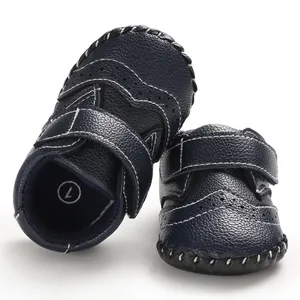 Detailed view of navy blue baby pre-walker shoes with brogue stitching and velcro