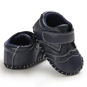 Macro detail of dark blue brogue baby walker shoes featuring elegant white stitching