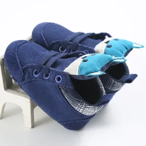 Dettaglio di scarpe per neonati in velluto blu con design a volpe in 3D cartoon.