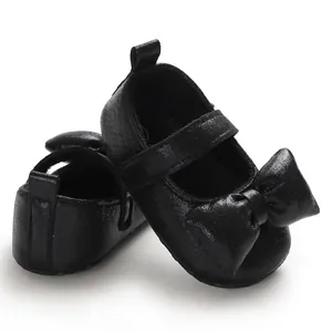 Detailed close-up view of black baby girl princess shoes with large bow decoration
