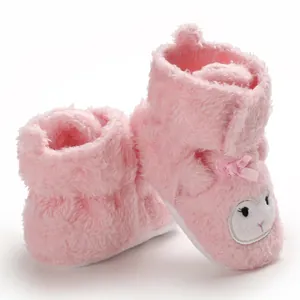 Vista dettagliata delle scarpine neonato rosa in peluche con ricamo agnello e fiocco