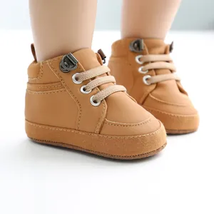 Gros plan de chaussures de marche montantes marron pour bébé avec semelles souples