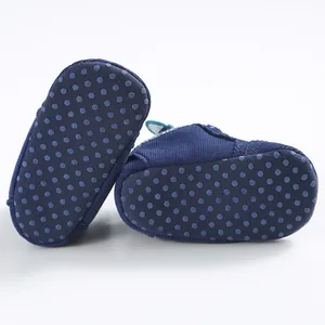 Vista dettagliata della suola antiscivolo a pois sulle scarpe primi passi blu bebè