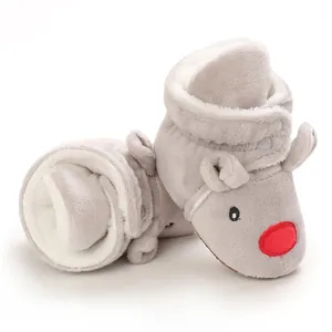 Dettaglio di scarponcini invernali in peluche grigio per neonati con viso e naso rosso