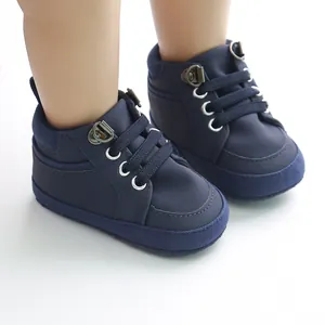 Gros plan de chaussures de marche pour bébé montantes bleu marine à semelles souples