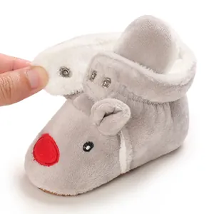 Dettaglio ravvicinato di scarpine in peluche per neonati con chiusura a scatto e fodera
