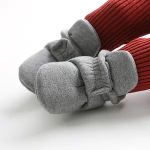 Close-up detail of soft-sole baby sock shoes with adjustable strap in grey.