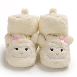 Dettaglio degli scarponcini in peluche per neonati con viso di pecora ricamato e fiocchi rosa.
