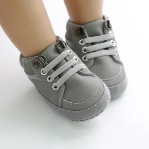 Gros plan de chaussures de marche montantes grises pour bébés avec semelles souples