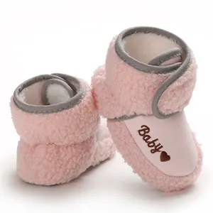 Close-up of soft pink sherpa baby snow boots with cute Baby embroidery and heart.