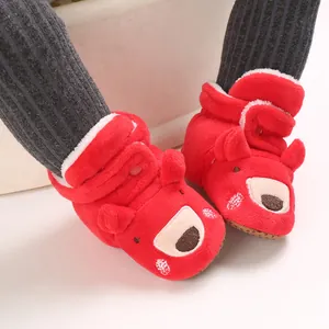 Dettaglio di scarpine rosse per neonati con orsetto e fodera in morbido peluche caldo