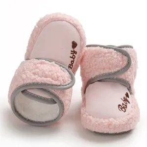 Close-up of warm pink fleece baby walking boots with soft sole and hook-loop strap