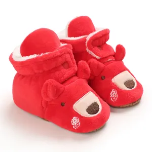 Dettaglio di scarpe invernali in peluche rosso per neonati con simpatico orsetto