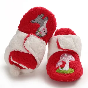 Detailed view of plush red and white baby shoes with cute mushroom and rabbit embroidery