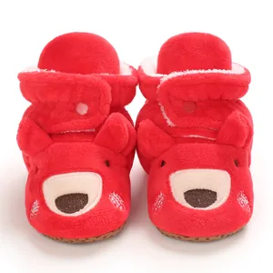 Primo piano di stivaletti rossi in peluche per neonati con suole morbide antiscivolo invernali.