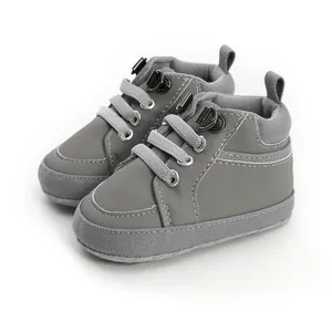 Vue de côté de chaussures de marche montantes pour bébé en gris avec des semelles souples.