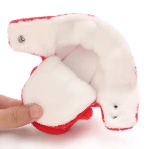 Primo piano della calda fodera in peluche e dei bottoni a pressione degli stivali rossi da neonato.