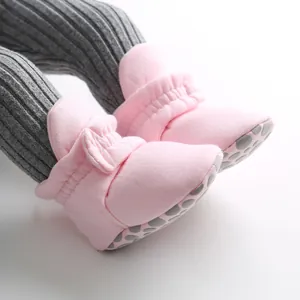 Close-up of pink soft-sole baby walking shoes with bow detail and anti-slip dots.