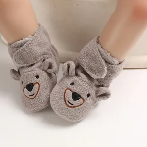 Dettaglio di scarpine per neonati in pile grigio con adorabile viso di orsetto e morbide