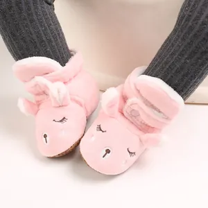 Primo piano di stivaletti invernali rosa in peluche con viso di animale cartoon