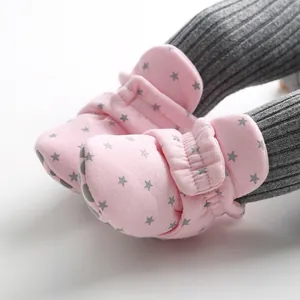Close-up detail of pink star-patterned baby shoes with soft soles and velcro straps