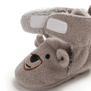 Dettaglio della scarponcina in peluche grigio per neonati con orsetto