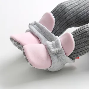 Close-up of pink and grey soft-sole baby sock shoes with anti-slip bottom for pre-walkers.