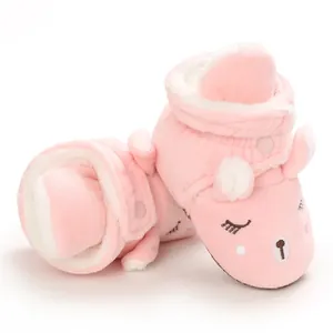 Vista dettagliata delle scarpine per neonati in peluche rosa con design a faccia di orso