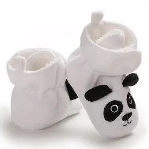 Vista macro dettagliata di scarpine primi passi in peluche bianco con faccia di panda