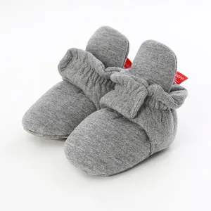 Detailed macro view of soft grey cotton baby booties with elastic ankle support