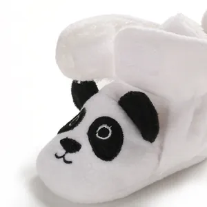 Dettaglio di una morbida scarpa in peluche per neonati con un simpatico panda nero