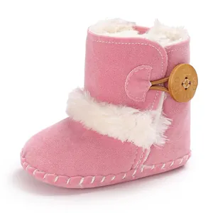 Detailed side view of pink baby snow boots with white faux fur lining and wooden button