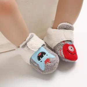 Close-up of soft fleece baby shoes with cute cartoon monster embroidery details