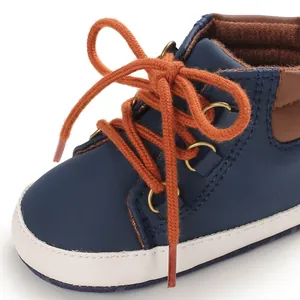 Vue détaillée de la chaussure montante pour bébé bleu marine avec lacets orange et coutures