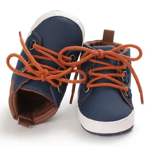 Vue détaillée de chaussures de marche montantes pour bébé bleu marine à lacets oranges
