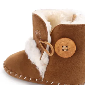 Close-up of brown baby winter boots with white faux fur lining and wooden button detail