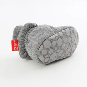 Close-up of grey baby sock shoes showing the non-slip sole and soft knit cotton fabric.