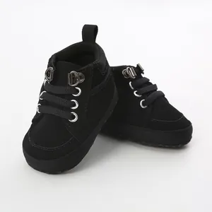 Vue détaillée des chaussures de marche montantes noires pour bébés à semelle souple.