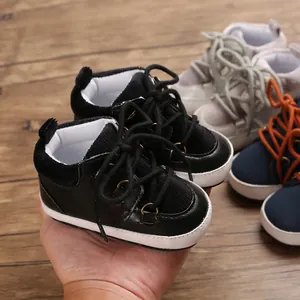 Gros plan de chaussures de marche pour bébé noires à semelle souple et lacets résistants