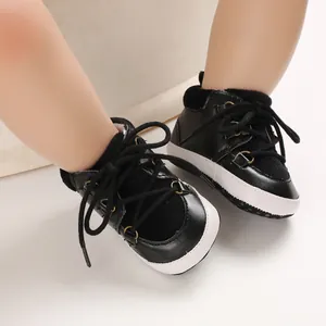 Gros plan sur des chaussures de marche pour bébé noires et blanches à lacets