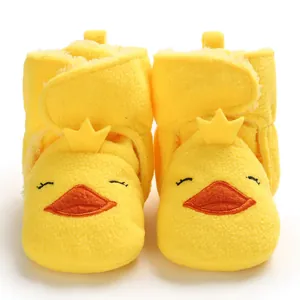 Dettaglio scarpe da neonato papera gialla con morbido ornamento a corona dorata