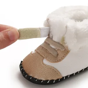 Nahaufnahme von warmen Baby-Schneeschuhen mit Kunstfell und Klettverschluss-Detail.