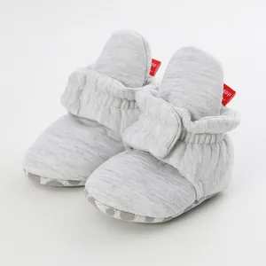 Close-up of grey infant soft-sole sock shoes featuring non-slip grip and ankle support
