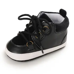 Vue détaillée de chaussures de marche noires pour bébés avec semelles blanches souples