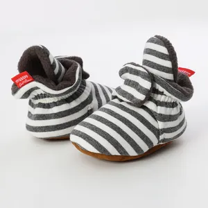 Close-up of striped baby booties with plush lining and soft brown soles for infants.