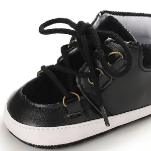 Vue détaillée de chaussures de marche bébé noires avec semelle souple et lacets