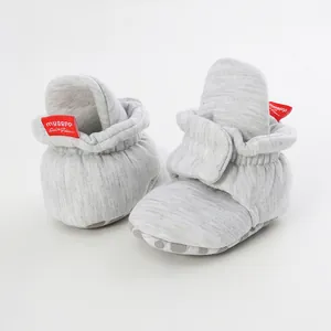 Soft grey cotton baby walker shoes with red brand tag and anti-slip sole detail