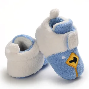 Detail of soft blue and white winter fleece baby booties with cartoon arrow patch